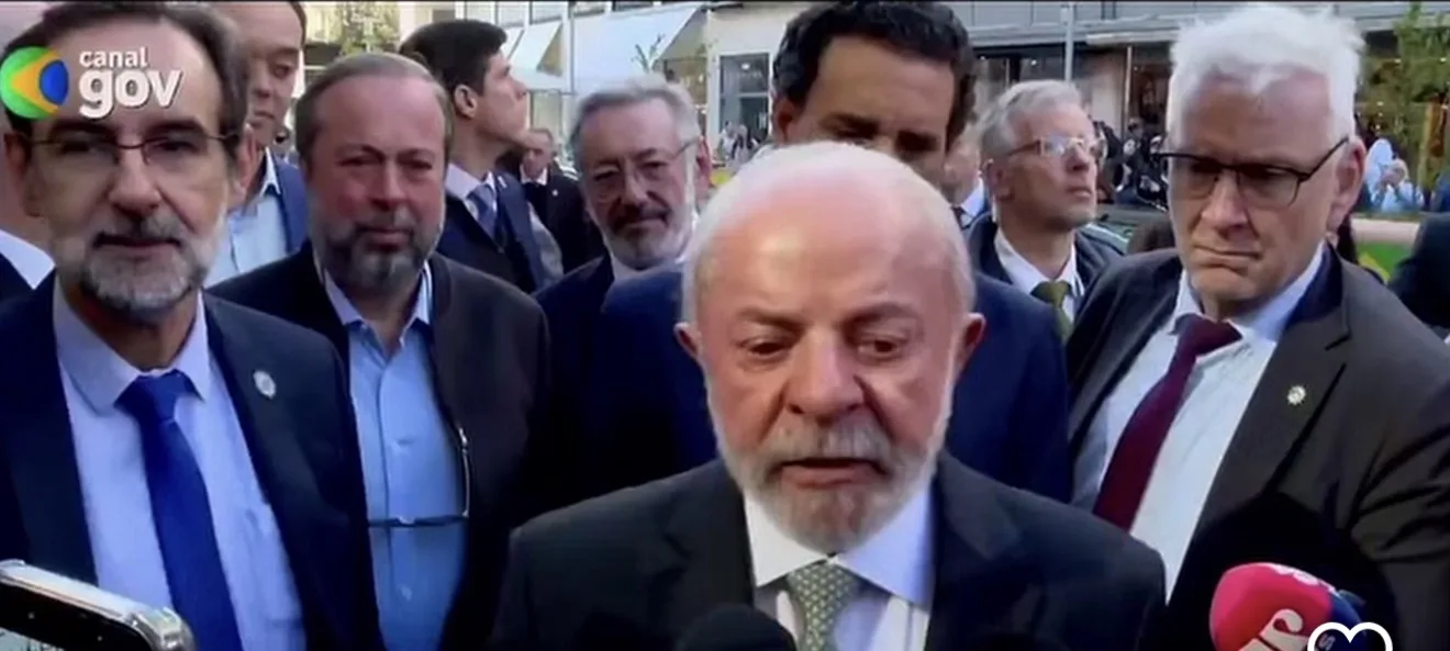 O presidente Luiz Inácio Lula da Silva em pronunciamento oficial cercado por ministros e jornalistas.