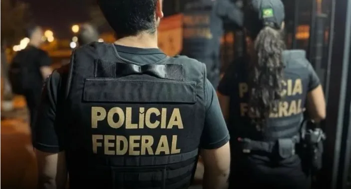 Agentes da Polícia Federal de costas durante operação oficial de busca e apreensão