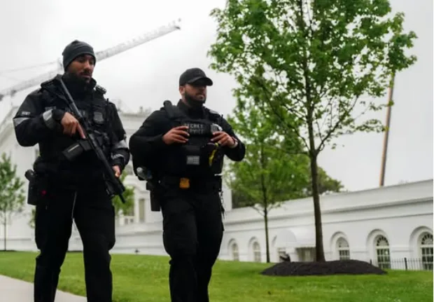 Agentes policiais e viaturas isolam o perímetro da Casa Branca após tiroteio em Washington.