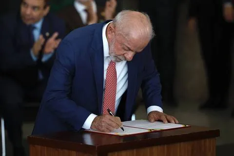 Fachada do Palácio do Planalto em Brasília sob iluminação diurna com o mastro da bandeira nacional ao fundo.