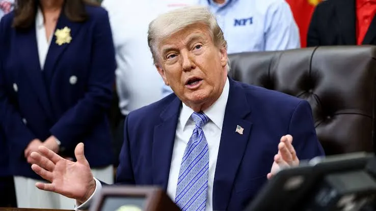 Donald Trump gesticula firmemente durante pronunciamento oficial em evento público.
