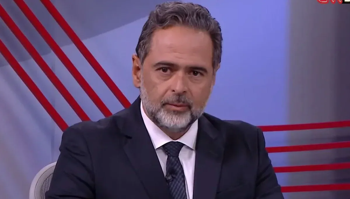 Jornalista Lourival Sant'Anna durante análise em estúdio de televisão com fundo azul.
