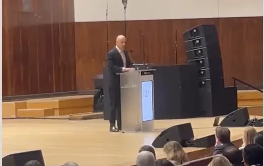 Ministro Alexandre de Moraes falando ao microfone em púlpito durante conferência internacional em Lisboa.