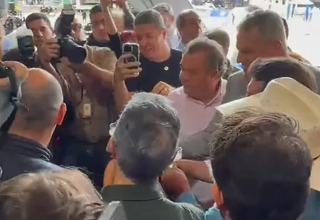 Governador Romeu Zema e o senador Flávio Bolsonaro conversam amigavelmente durante evento do agronegócio em Minas Gerais.