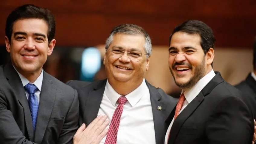 Flávio Dino e Jorge Messias sentados durante cerimônia institucional