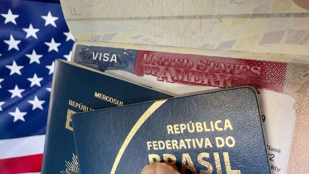 Passaporte brasileiro diante da bandeira dos Estados Unidos em referência à emissão de vistos