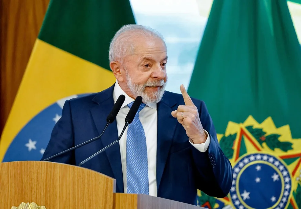 Presidente Lula discursa diante de bandeiras do Brasil