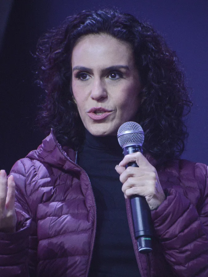 Jornalista Malu Gaspar falando ao microfone em evento público