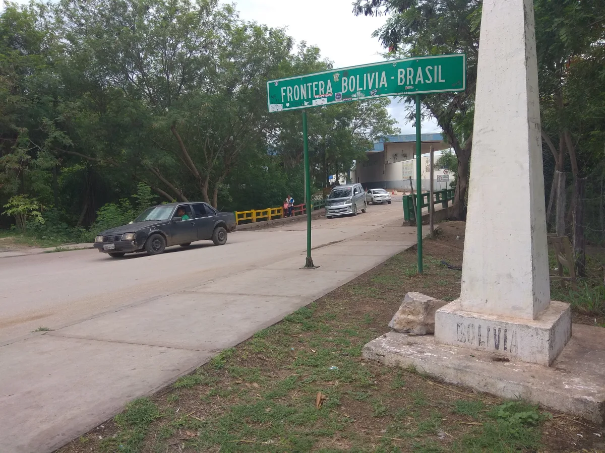Marco de fronteira Bolívia-Brasil em Corumbá, com placa Frontera Bolivia-Brasil e posto de controle ao fundo
