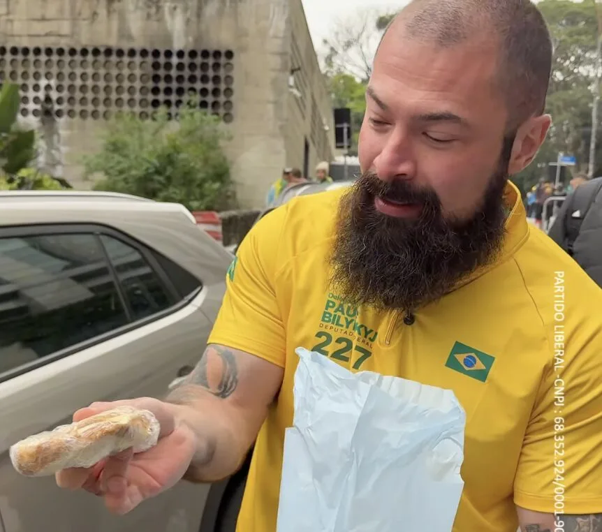Paulo Bilynskyj exibe pão com mortadela distribuído a manifestantes de esquerda próximos à Paulista