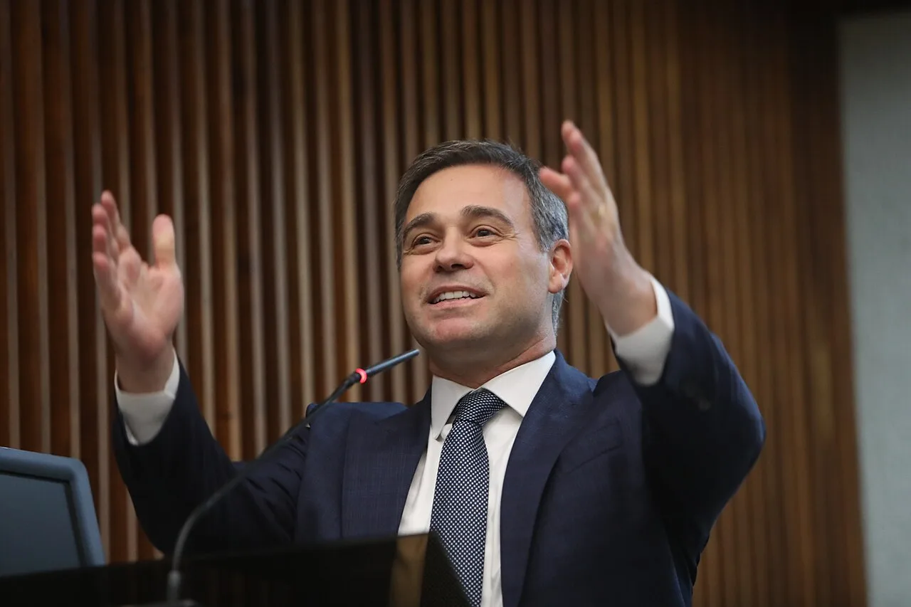 Ministro André Mendonça do STF, de terno escuro e gravata azul, fala ao microfone em sessão solene na Assembleia Legislativa do Paraná