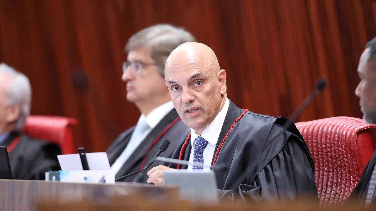 Ministro Alexandre de Moraes em sessão oficial, com toga e microfone à frente