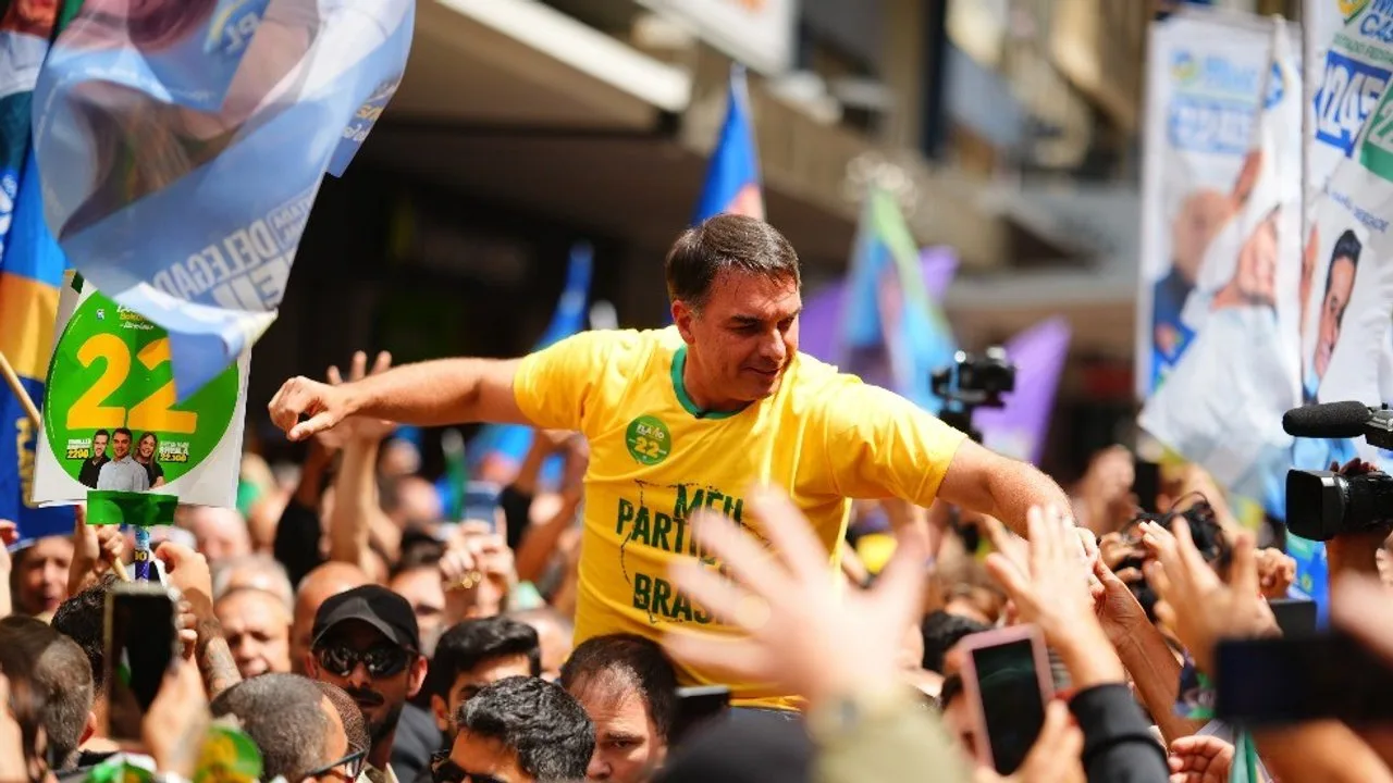Flávio Bolsonaro carregado por apoiadores em ato de campanha