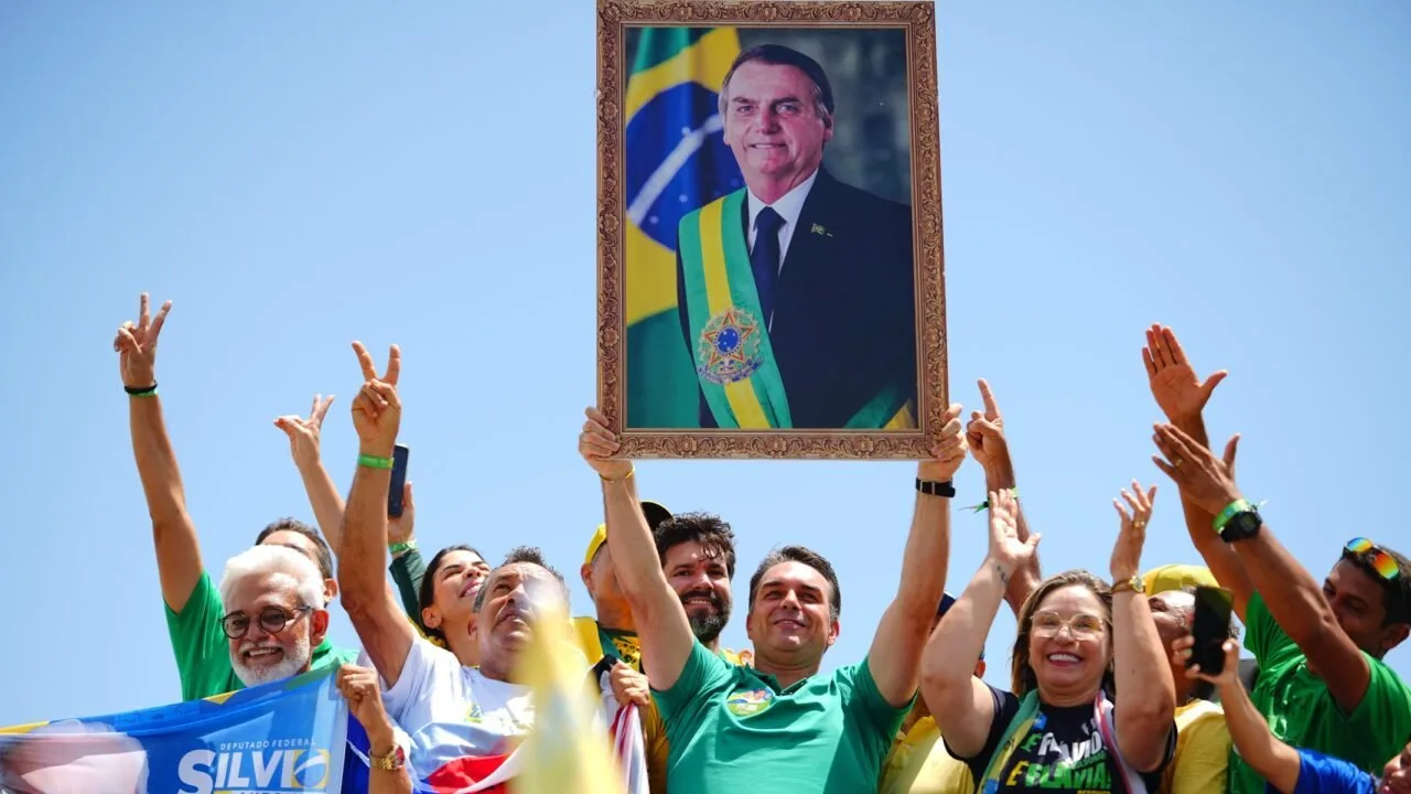 Flávio Bolsonaro exibe quadro com a imagem de Jair Bolsonaro em ato de campanha
