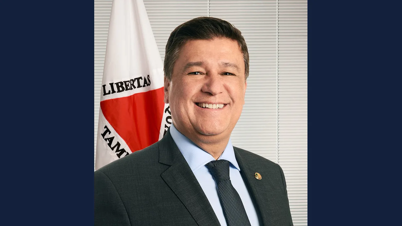 Retrato oficial do senador Carlos Viana diante da bandeira de Minas Gerais
