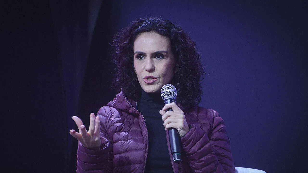 A jornalista Malu Gaspar fala ao microfone durante entrevista em evento