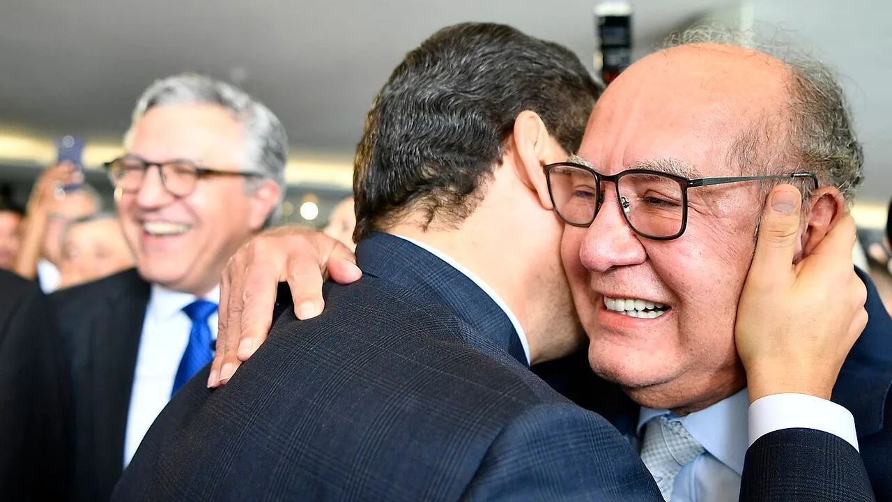 Ministro Gilmar Mendes, decano do STF, sorri ao ser abraçado durante a solenidade de abertura do ano legislativo no Congresso Nacional